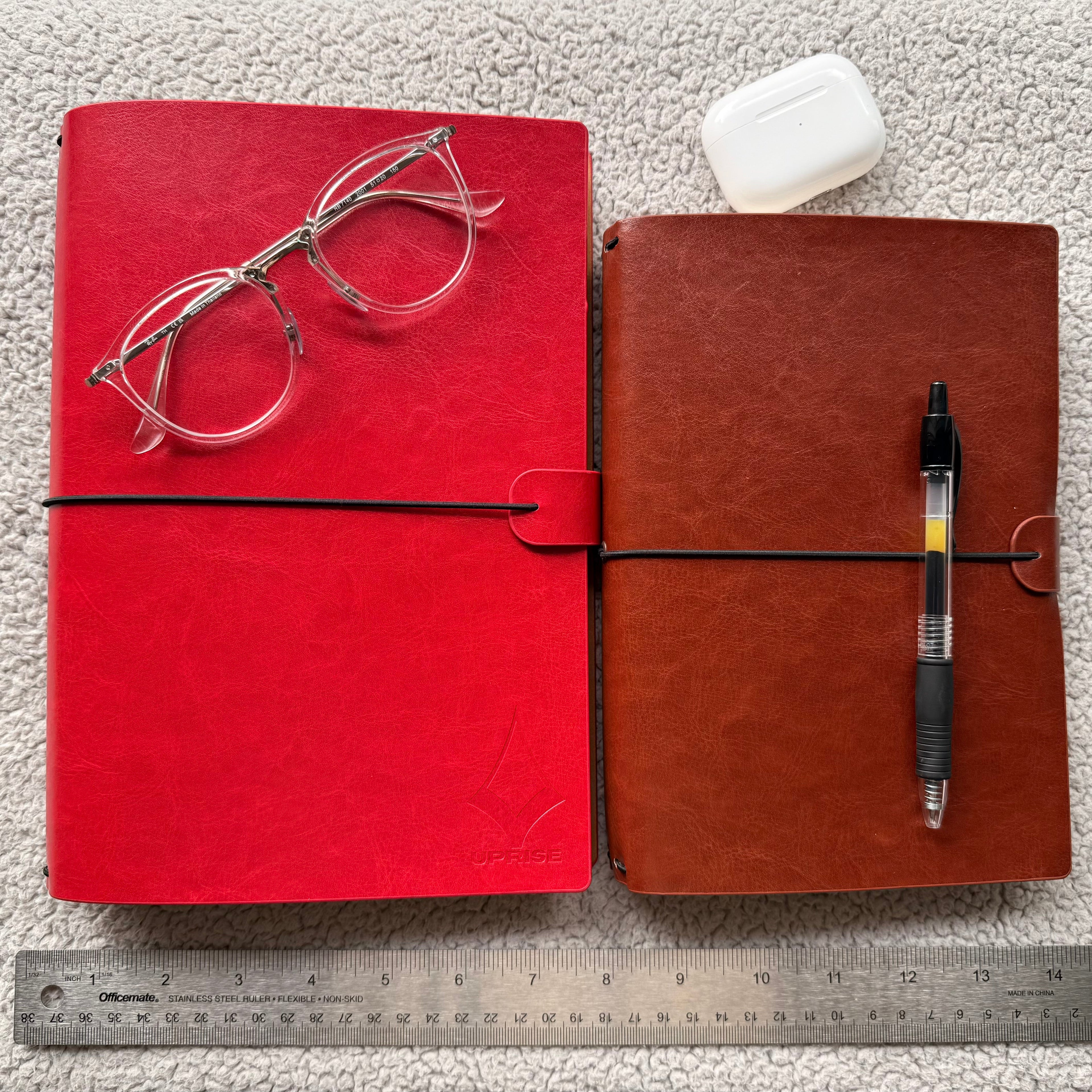 Showcasing Uprise Notebooks in both A5 and B5 sizes placed next to a ruler for size comparison, highlighting their compact and versatile dimensions, customizable modular design, and premium vegan leather covers.