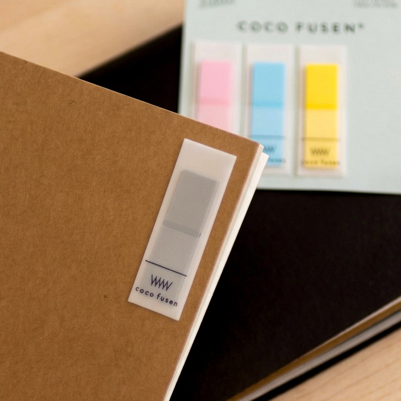Notebook with a package of colorful sticky notes on a wooden surface