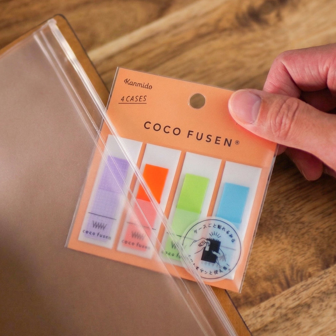 Coco Fusen colorful sticky notes in clear packaging held by a hand on a wooden surface